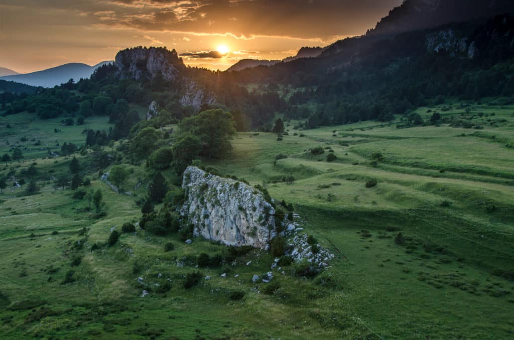 Puesta de sol en las montañas verdes de Rasos de Peguera al atardecer (Cataluña, España)