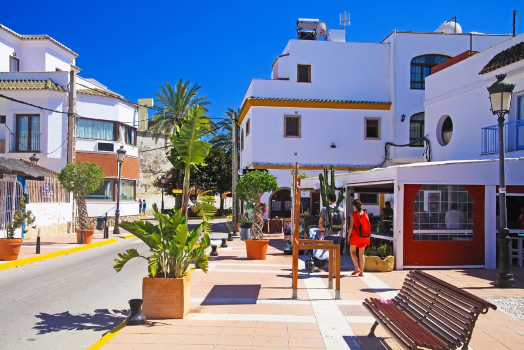 Zahara de los Atunes, Spain - June 9. 2016: Traditianal beautiful quiet sleepy atlantic coastal town, palm trees, square with white houses, blue clear summer sky